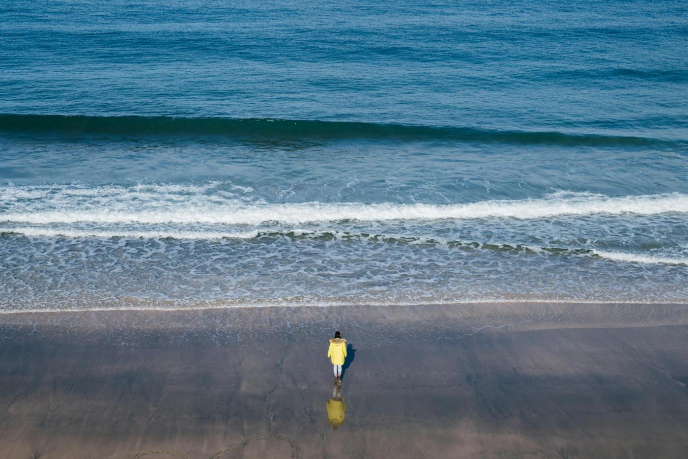 une personne en bord de mer regardant l'horizon